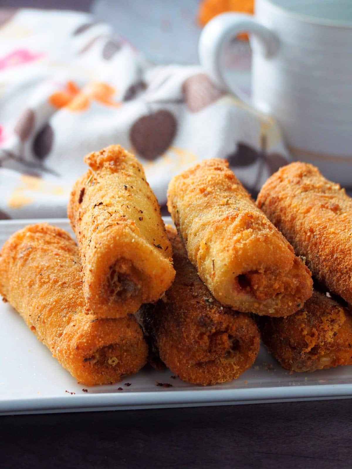 crunchy bread rolls filled with ham and cheese on a white serving platter