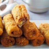 ham and cheese bread roll-ups on a white serving plate