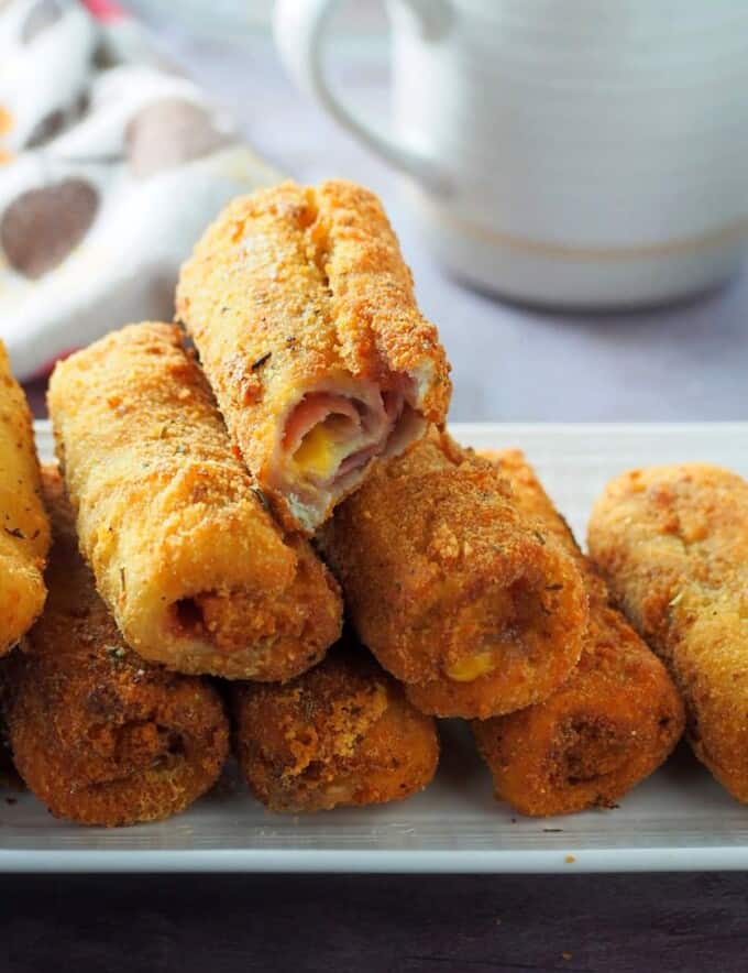 ham and cheese bread roll-ups on a white serving plate