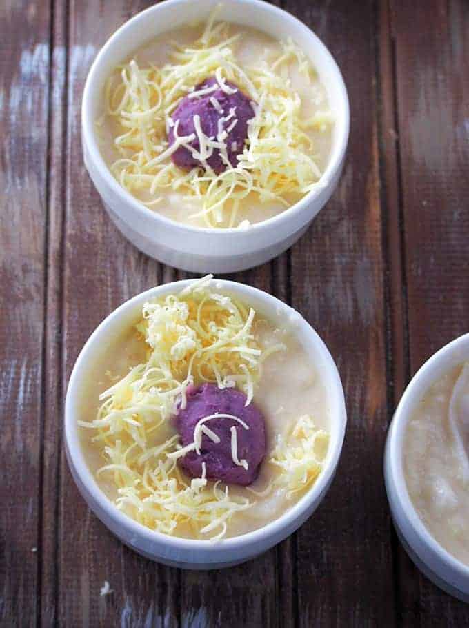 sprinkling cheese on cassava and ube mixture