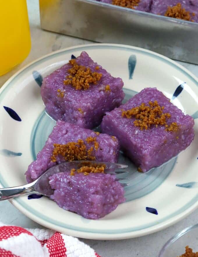 slices of biko with ube and latik on a blue printed plate