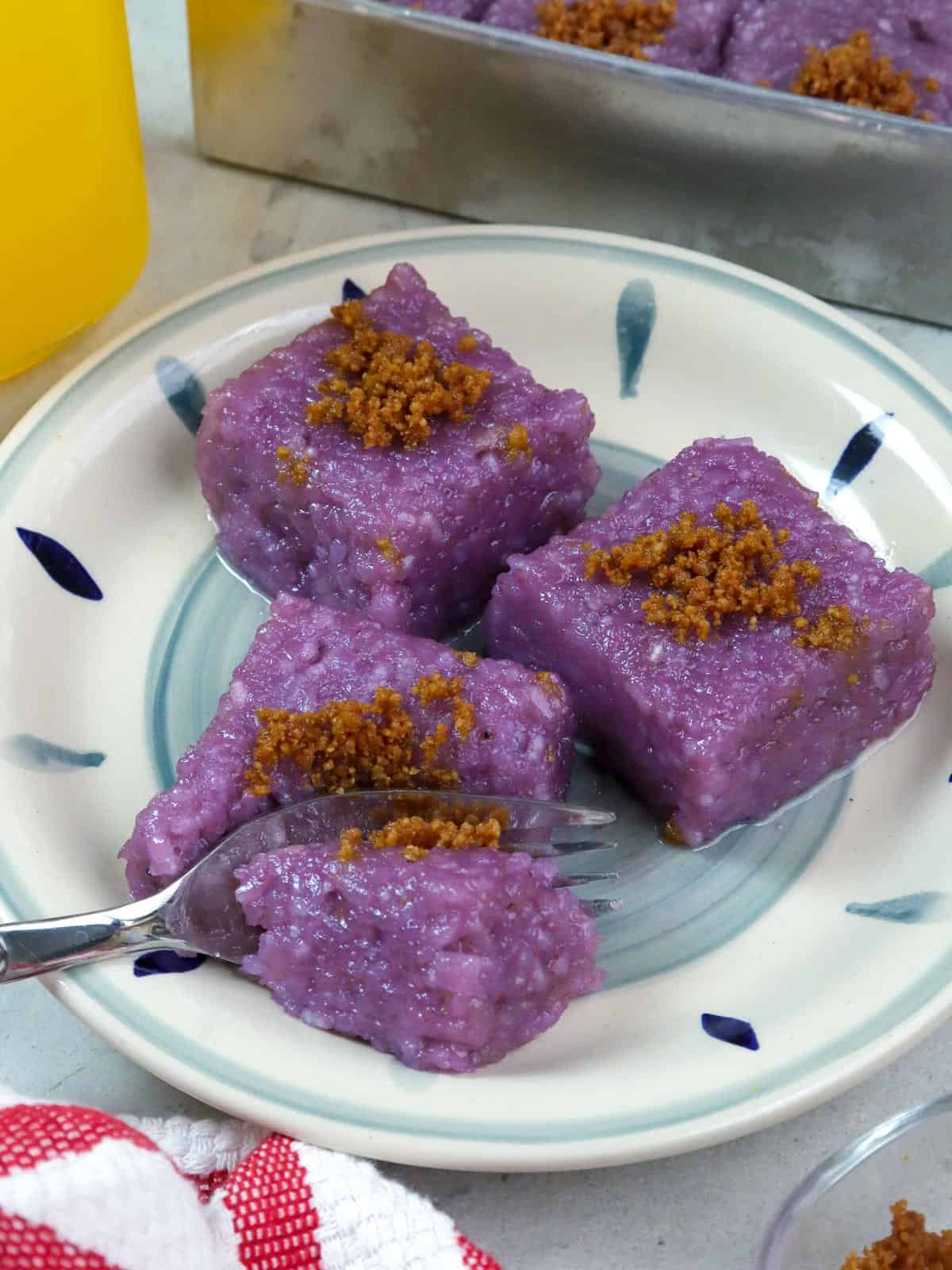 slices of biko with ube and latik on a blue printed plate