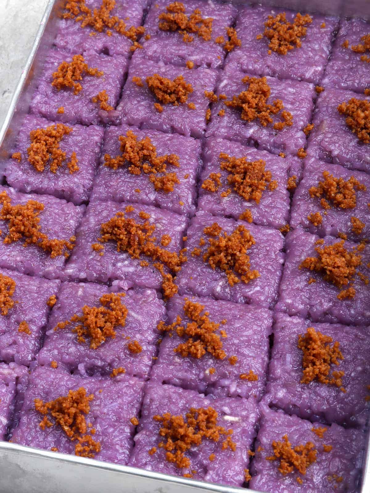 Ube Biko in an aluminum tray with latik topping