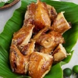 chopped lechon manok on a banana leaf lined serving platter