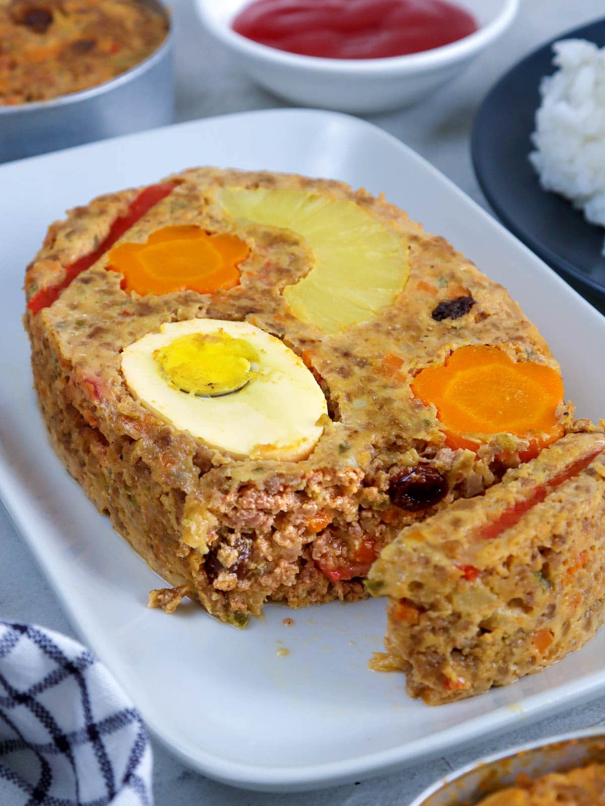 serving a slice of Marikina meatloaf from a platter