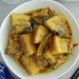 yellow adobo in a white serving bowl