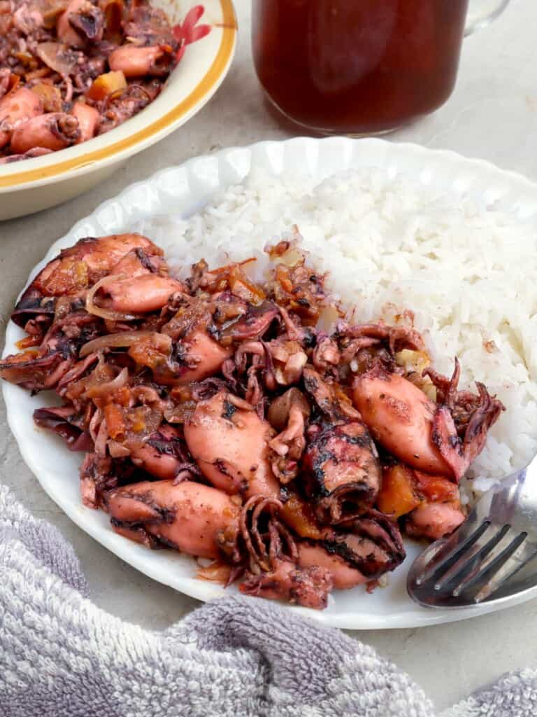 sauteed squid on a white plate with steamed rice