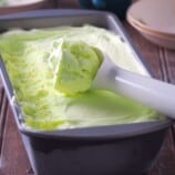 scooping buko pandan ice cream from a metal loaf pan