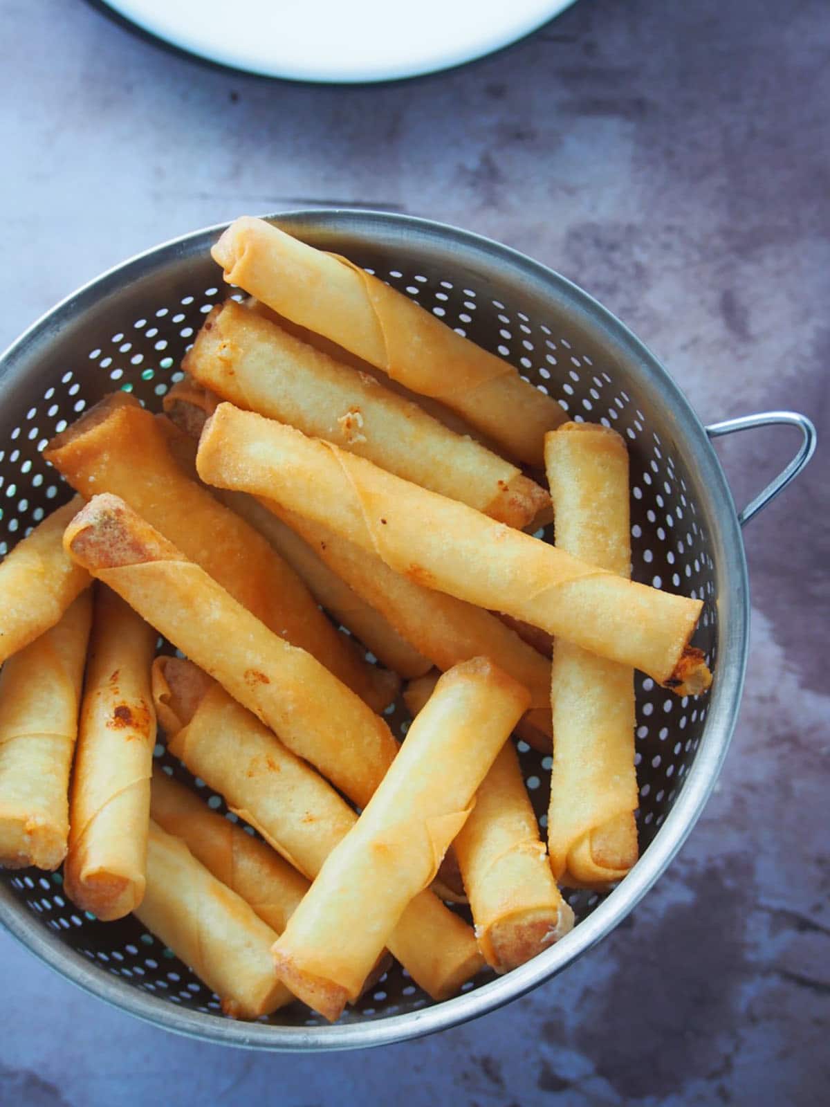 fried cheese sticks on a metal colander