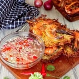 crispy ukoy made with papaya on a wooden board with spicy vinegar in a bowl on the side