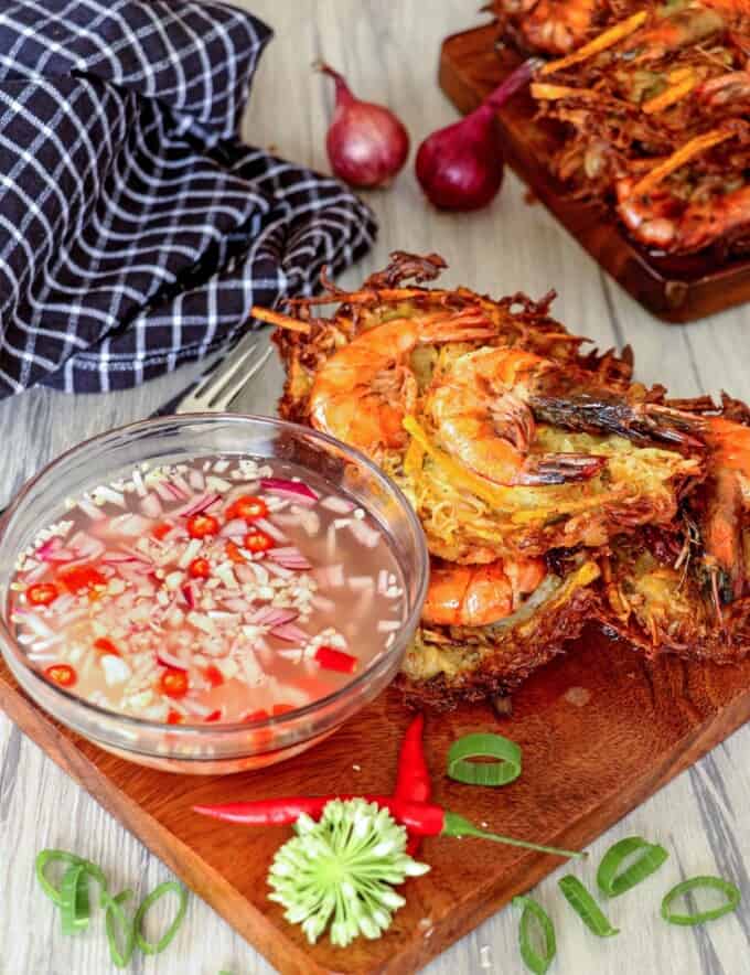 crispy ukoy made with papaya on a wooden board with spicy vinegar in a bowl on the side