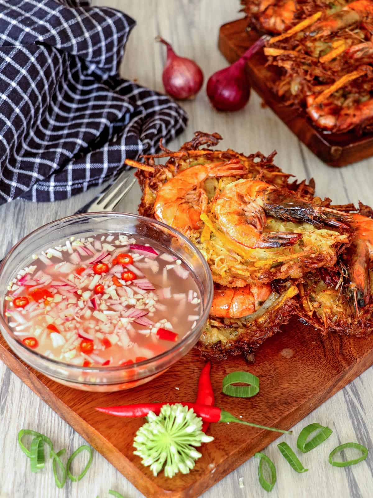 crispy ukoy made with papaya on a wooden board with spicy vinegar in a bowl on the side