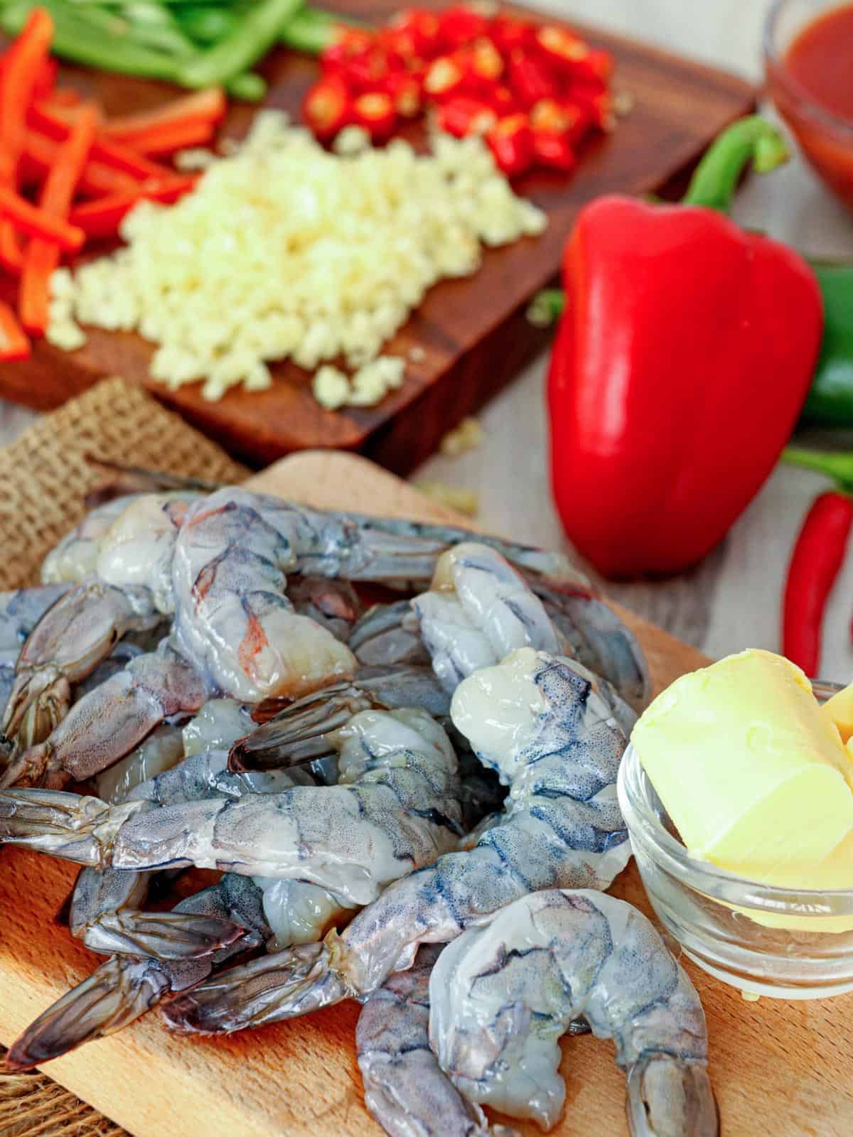 peeled shrimp, minced garlic, butter, red bell peppers, chili peppers, tomato sauce