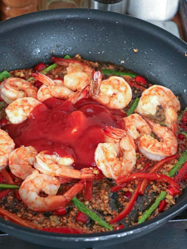 cooking shrimp in garlic in a wide pan