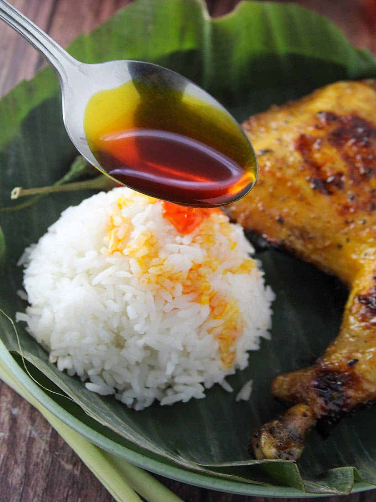 pouring chicken oil over rice