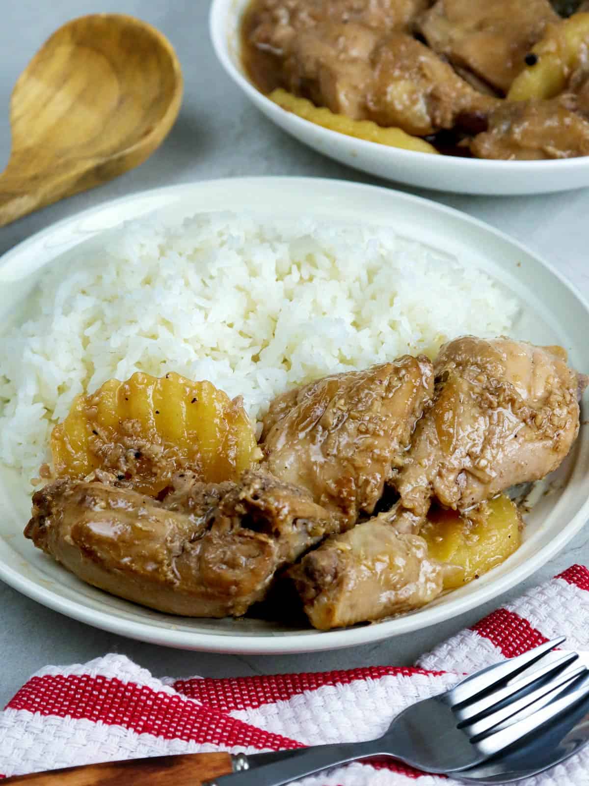 adobong manok with steamed rice on a white plate