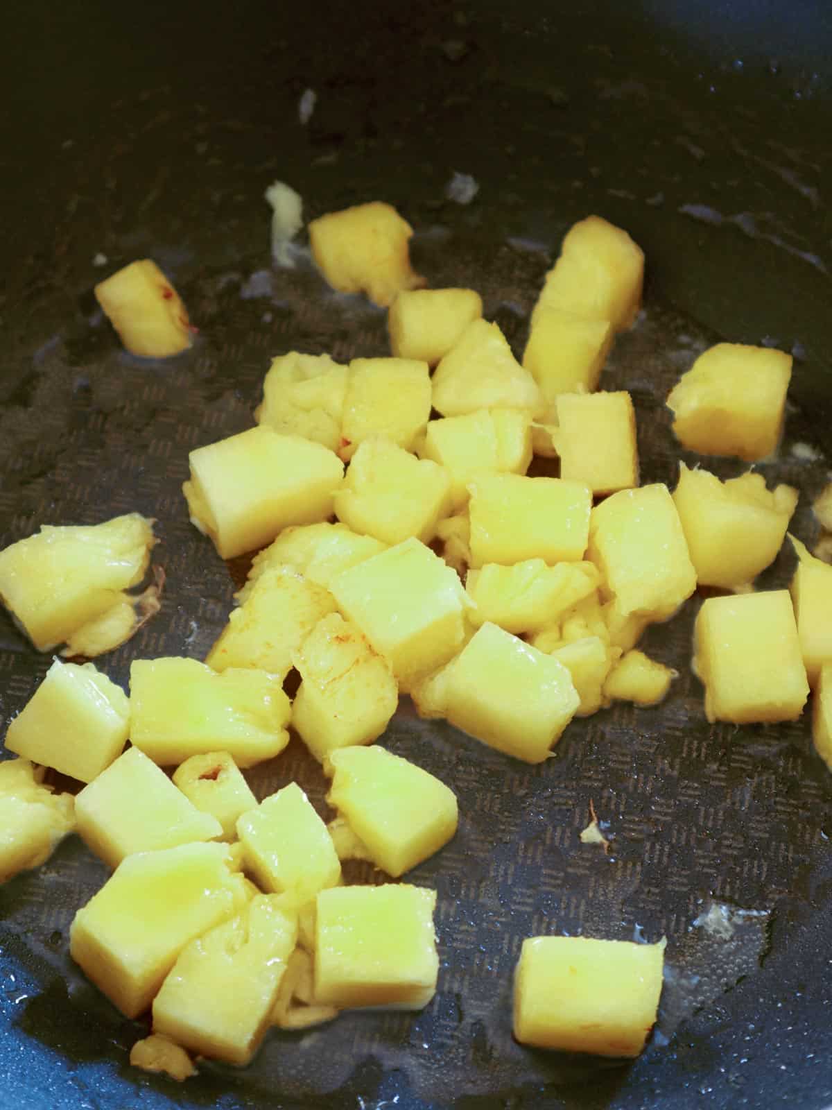 caramelizing pineapple cubes in a pan