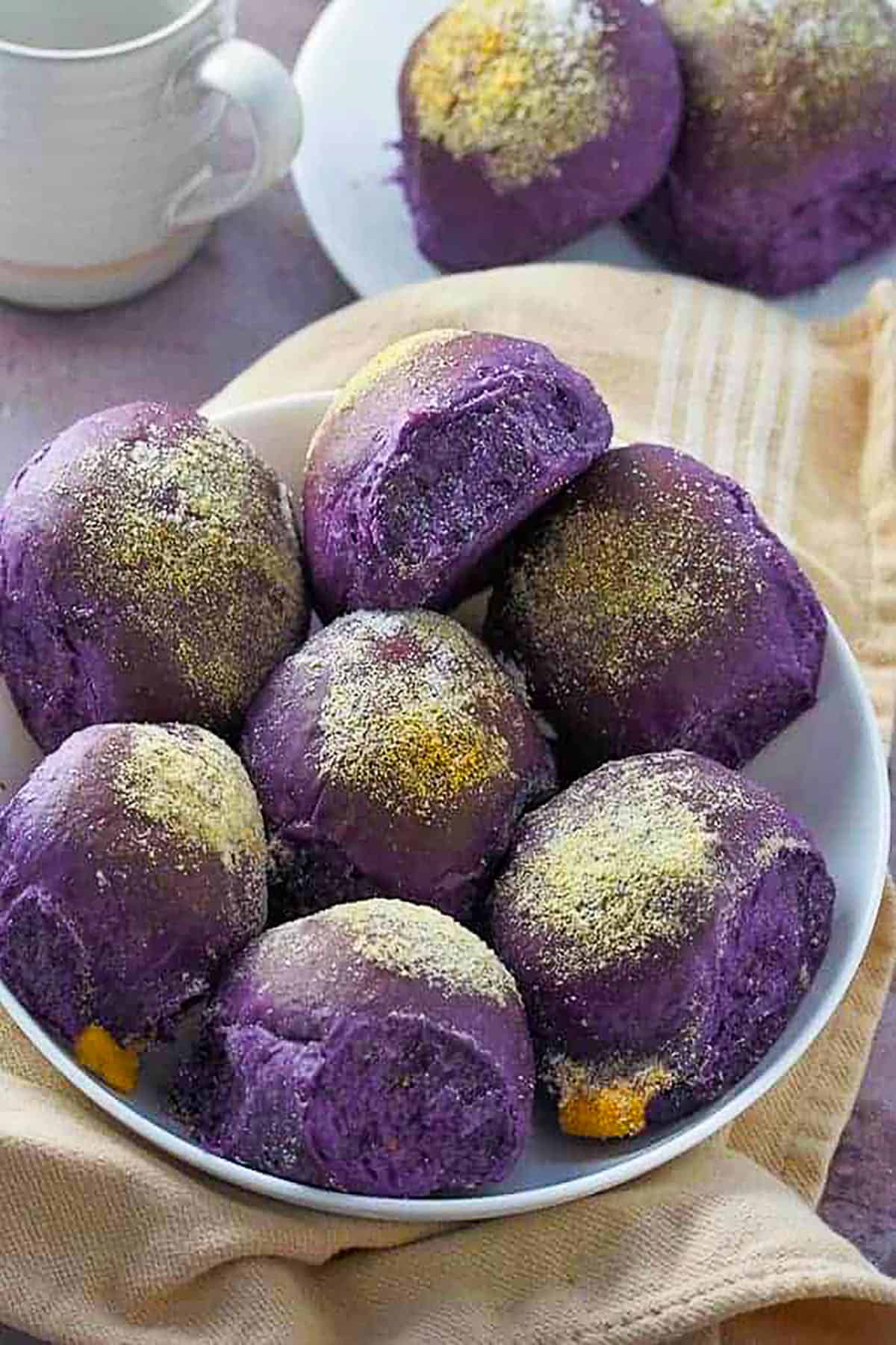 ube cheese pandesal on a white plate.