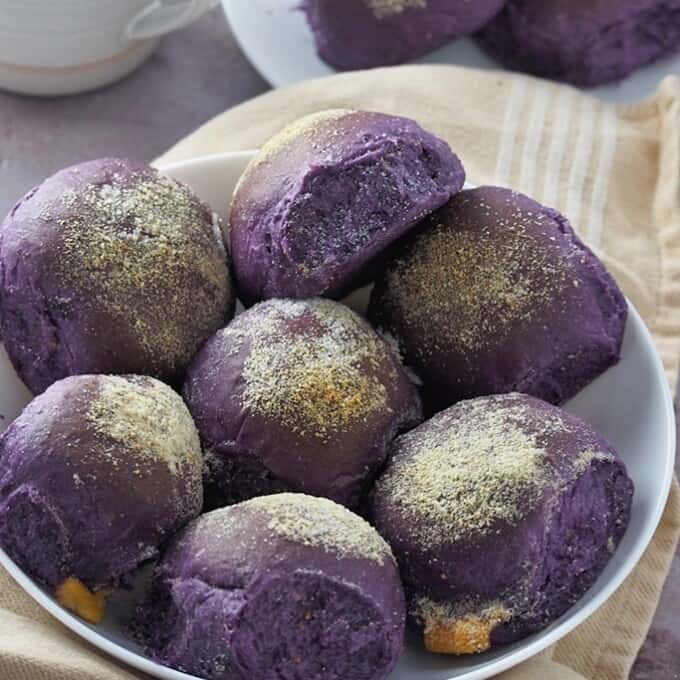 ube cheese pandesal on a white plate.