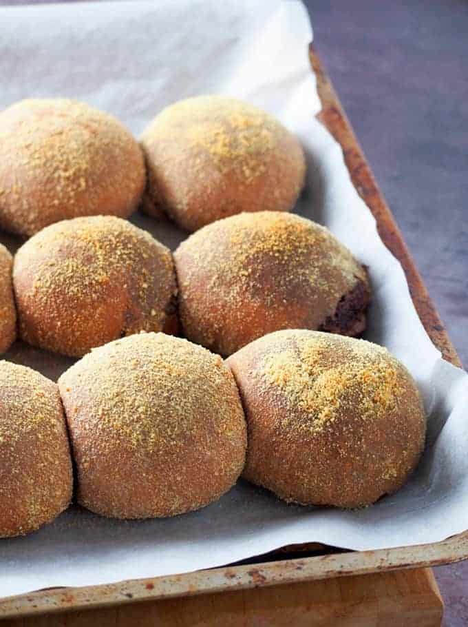 Chocolate Pandesal baked on a parchment-lined baking sheet