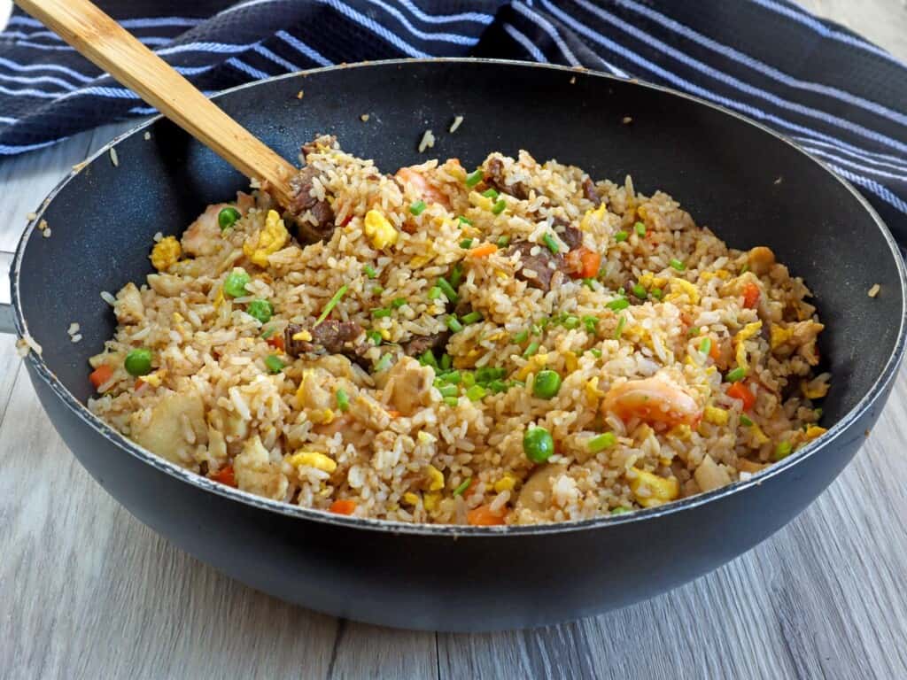 house fried rice with shrimp, beef, and chicken in a pan