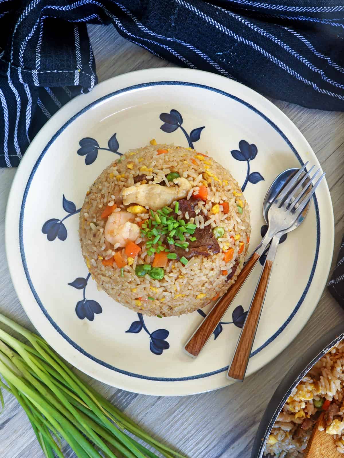 fried rice with meat and shrimp on a serving plate