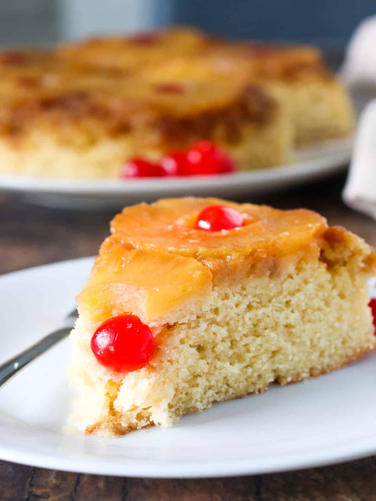 slice of pineapple upside-down cake on a white plate