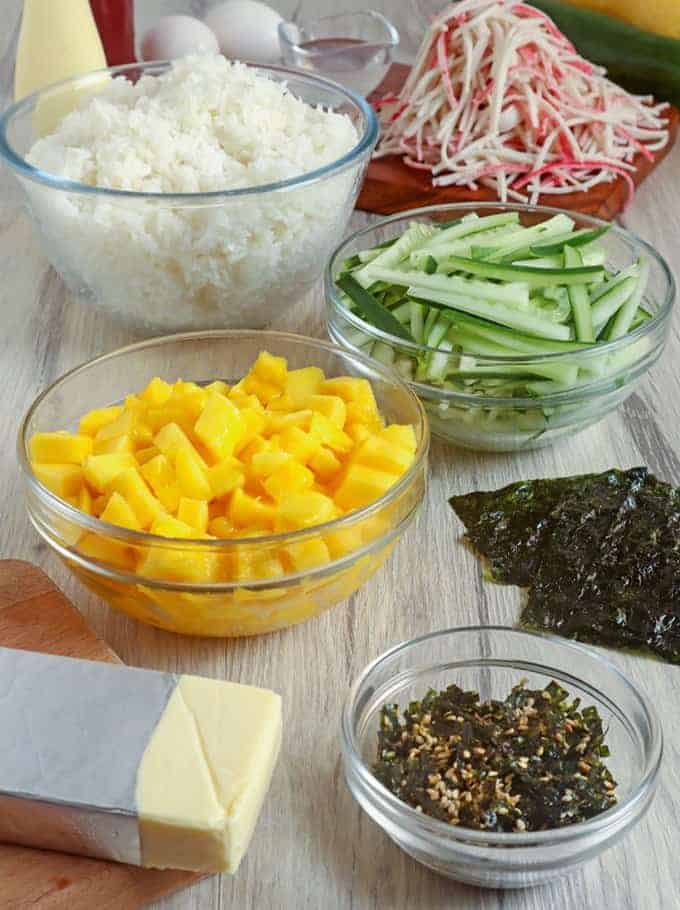 sushi rice, chopped mangoes, sliced cucumbers, nori sheets, furikake, imitation crab, cheese