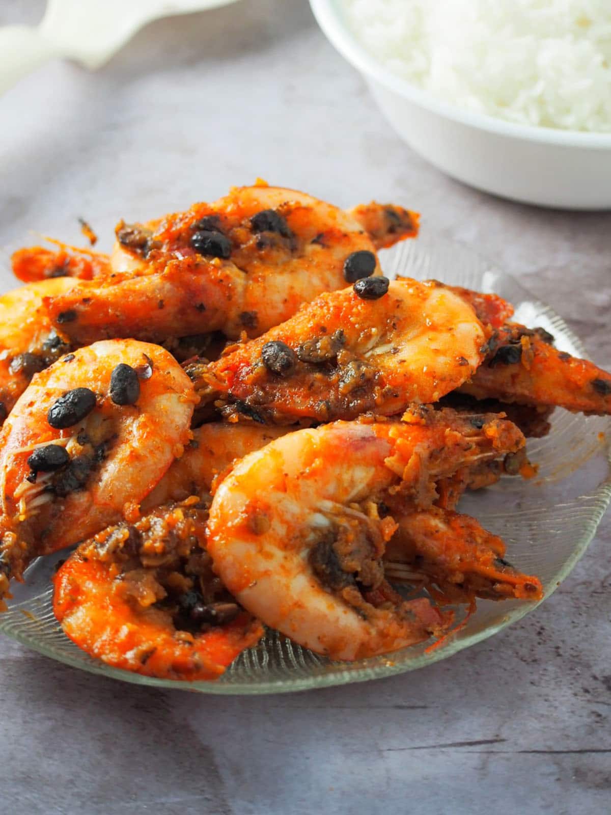 Shrimp in Black Bean Sauce on a serving plate with a bowl of steamed rice on the side