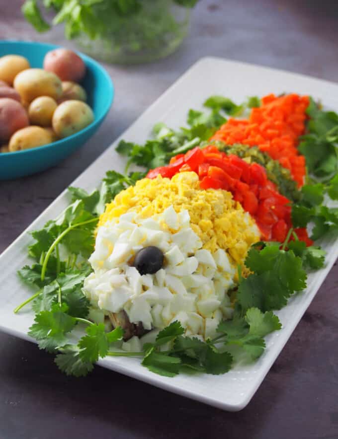 pescao en mayonesa or steamed fishdecorated with chopped eggs, roasted bell peppers, sweet relish, and carrots