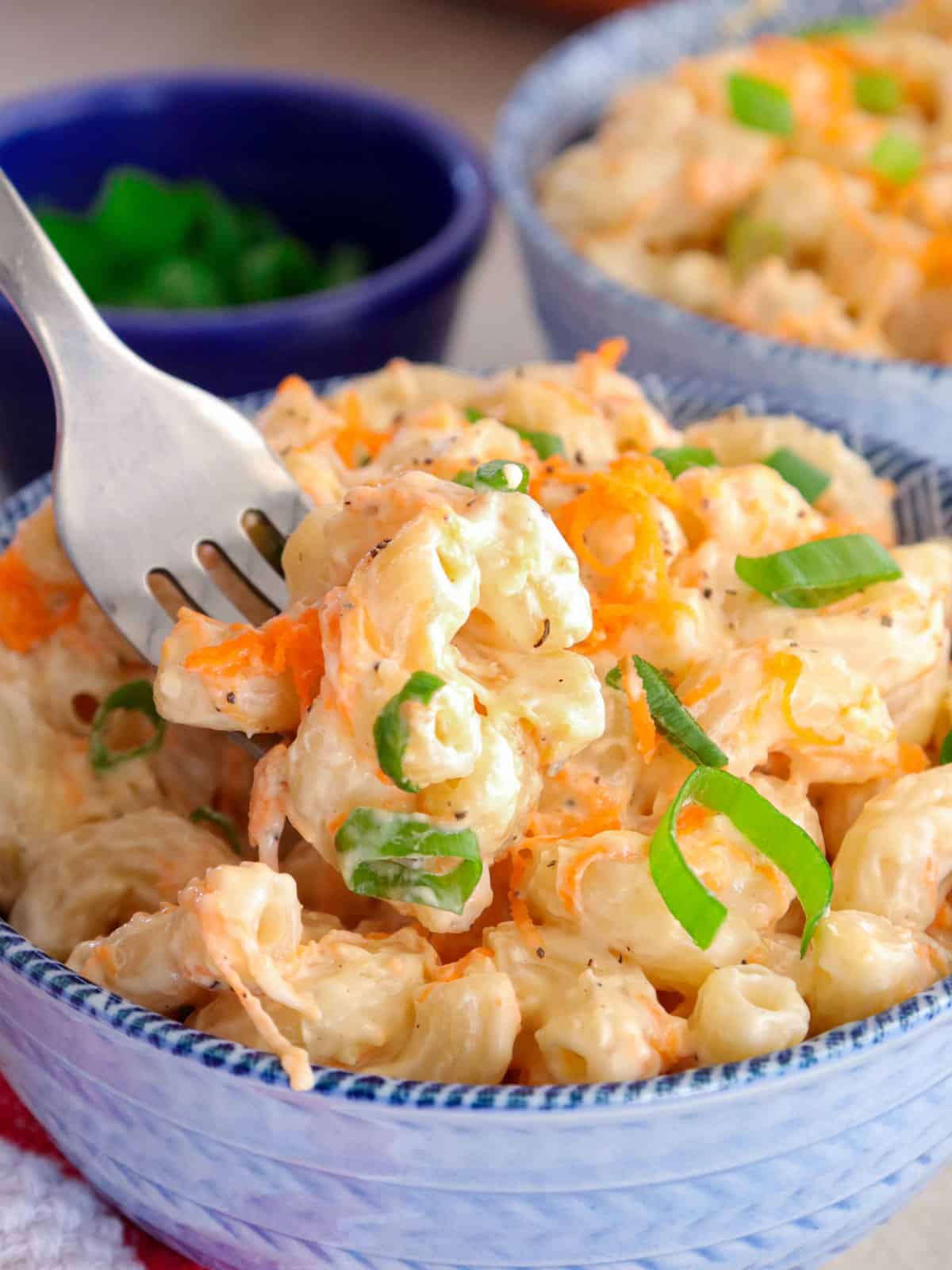 eating Hawaiian mac salad from a bowl with a fork.