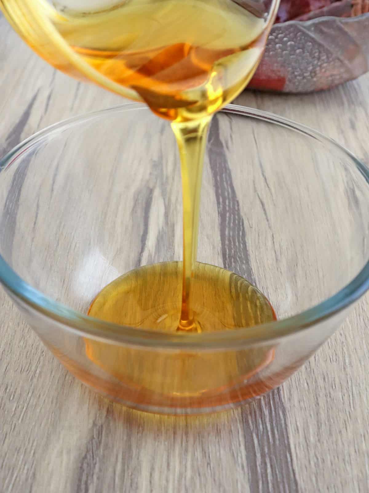 pouring honey to a clear glass bowl