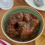 Pork Adobo with coconut milk in a blue serving bowl.