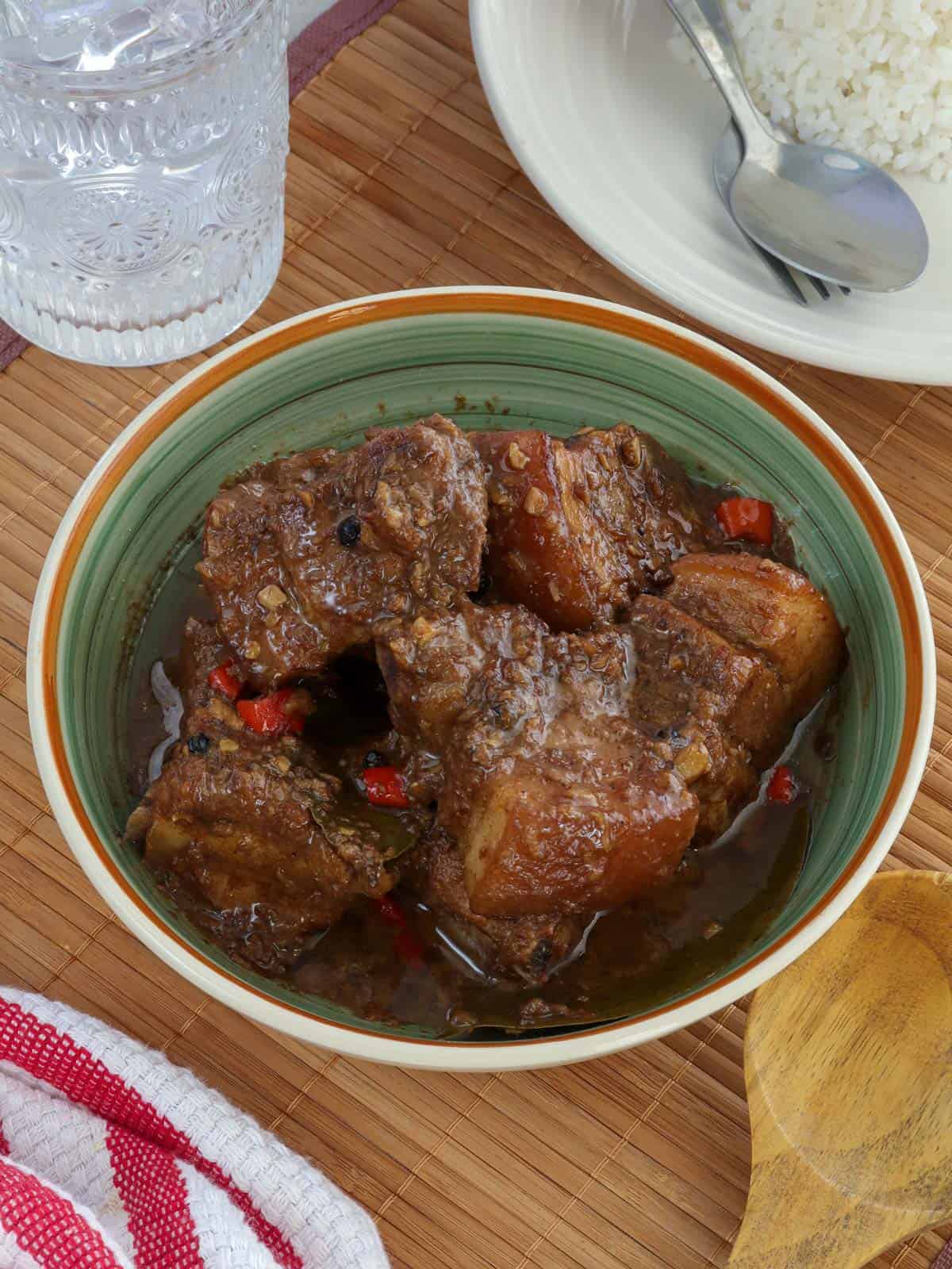 Pork Adobo with coconut milk in a blue serving bowl.