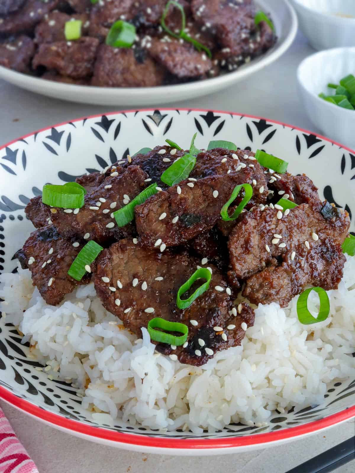 beef bulgogi over steamed rice on a white plate