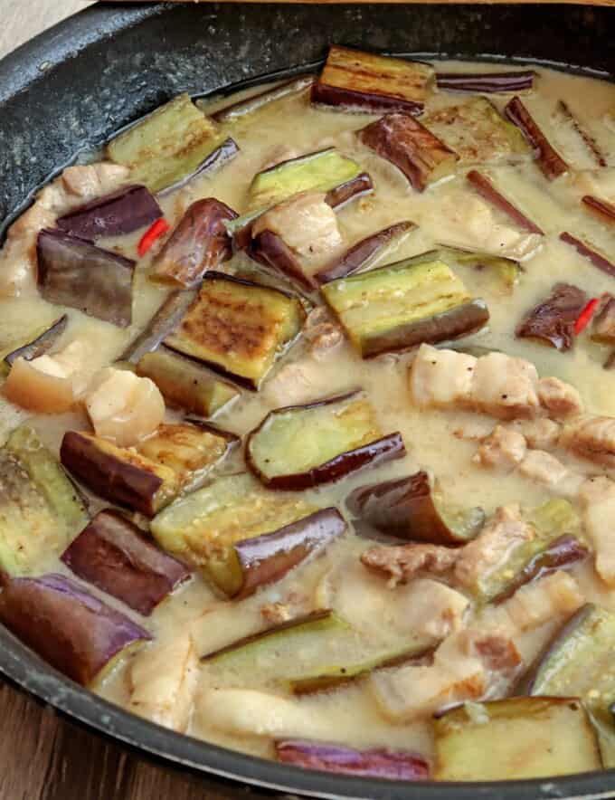 eggplant and pork in coconut sauce in a skillet