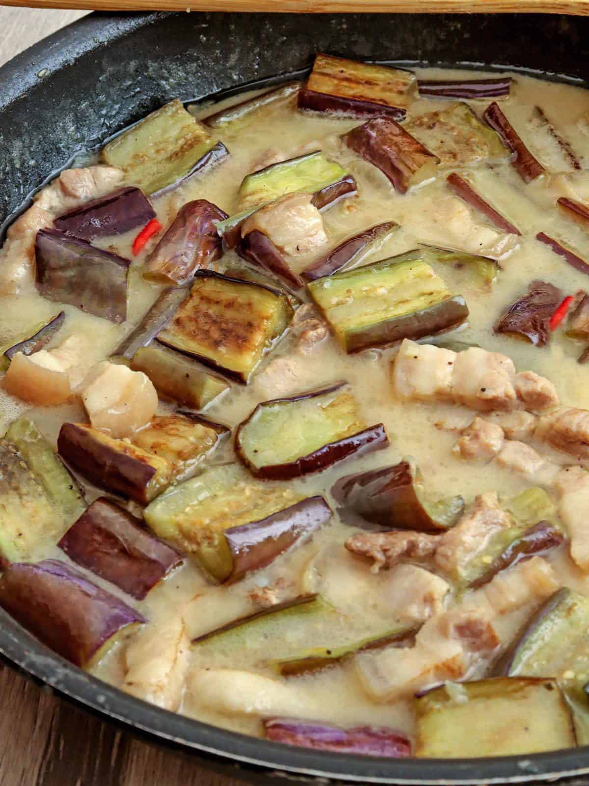 eggplant and pork in coconut sauce in a skillet