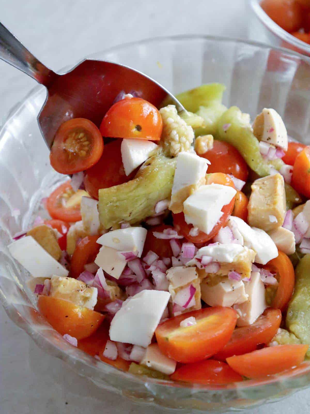 mixing ensaladang talong in a bowl