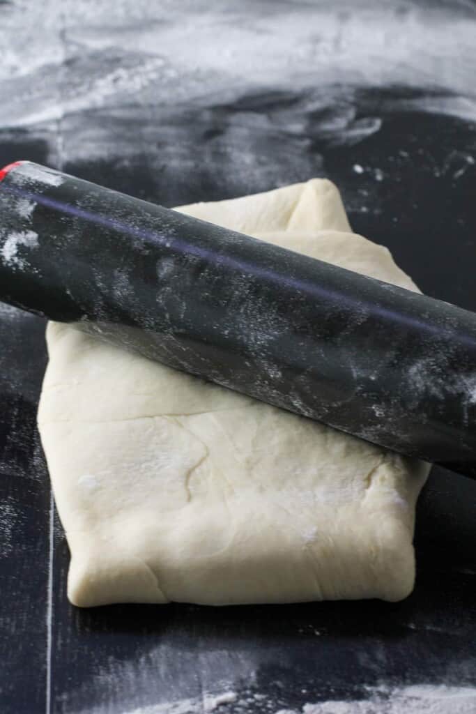 rolling the folded dough with a rolling pin