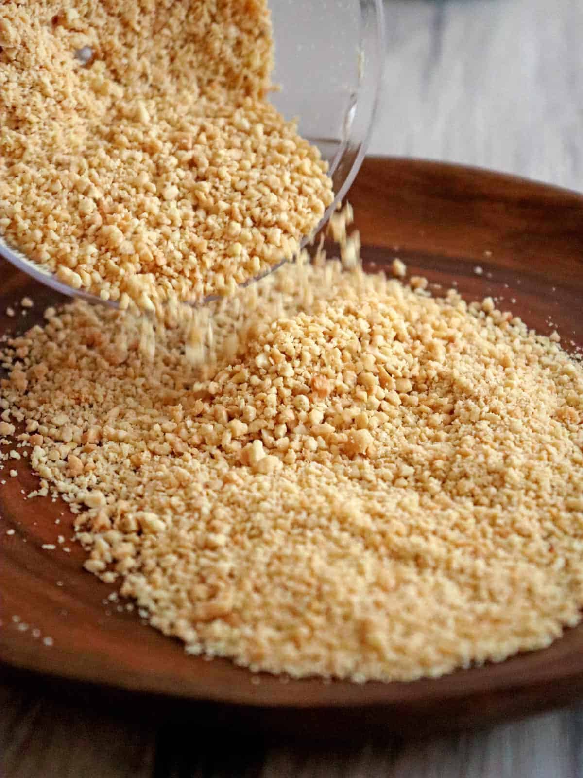 pouring ground peanuts to a brown plate