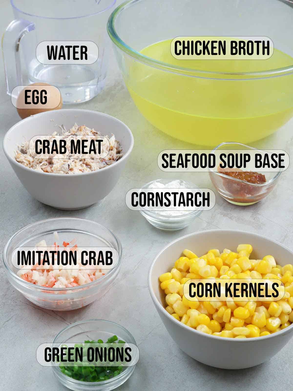 lump crab meat, imitation crab, corn kernels, chopped green onions, chicken broth, corn starch, seafood base, egg in bowls.