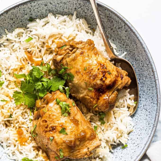 pressure cooker adobong manok on a bed of steamed rice in serving bowl