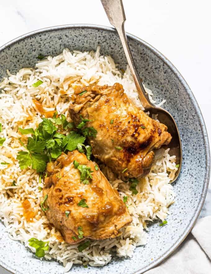 pressure cooker adobong manok on a bed of steamed rice in serving bowl