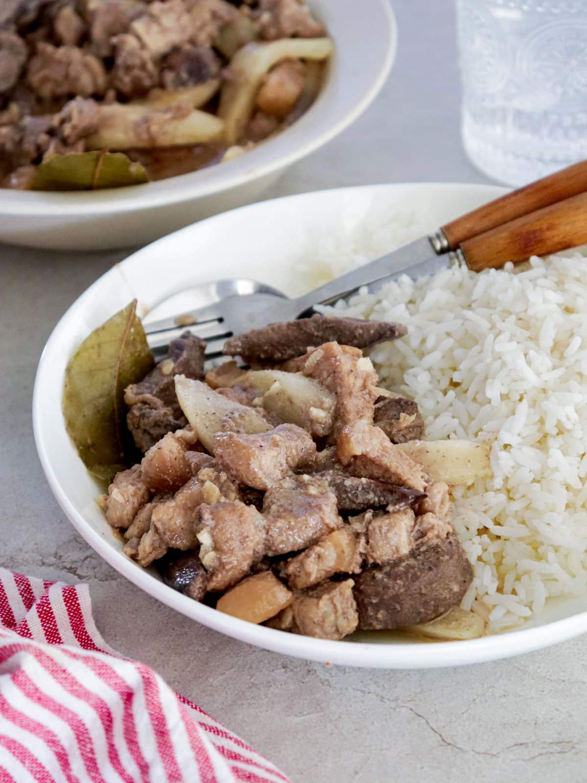 kilawing labanos at baboy on a white serving plate with steamed rice on the side..