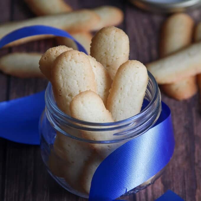 Filipino cat's tongue cookies in a glass jar with blue ribbon