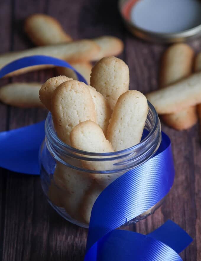 Filipino cat's tongue cookies in a glass jar with blue ribbon