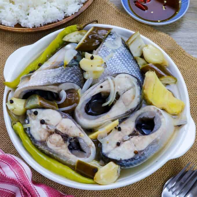paksiw na bangus with eggplant and chili peppers in a white serving bowl