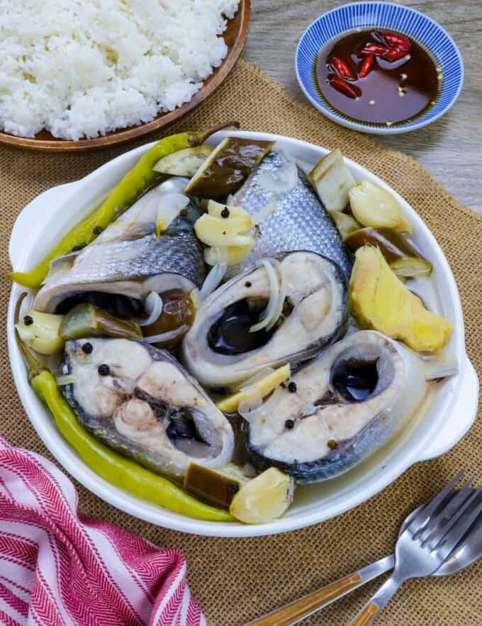 paksiw na bangus with eggplant and chili peppers in a white serving bowl