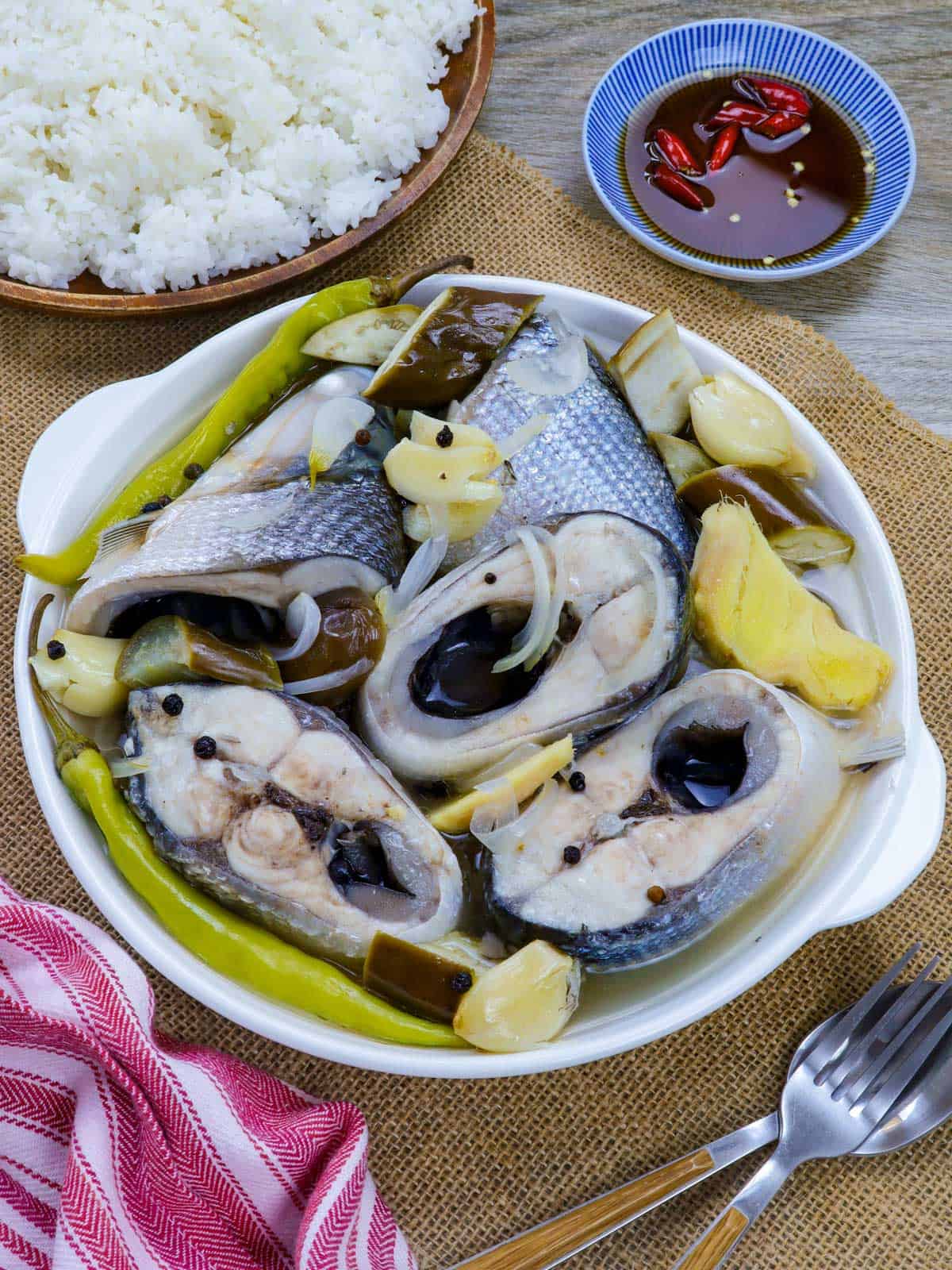 paksiw na bangus with eggplant and chili peppers in a white serving bowl