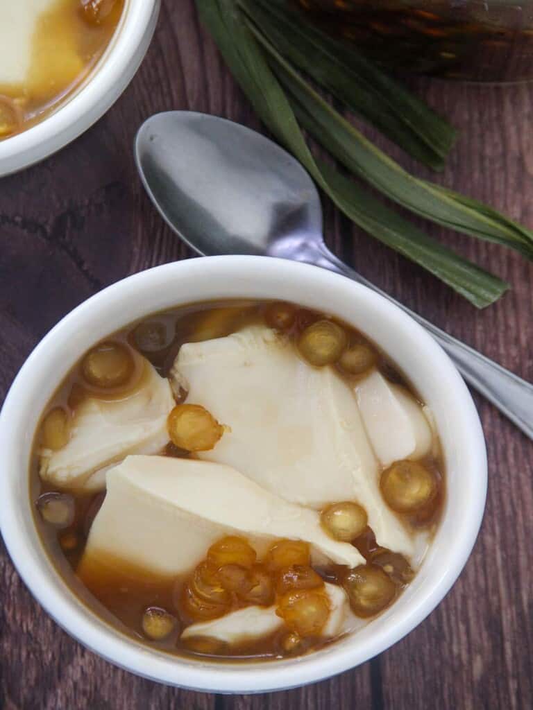 Filipino Sweetened silken tofu dessert with sago and syrup in a small bowl